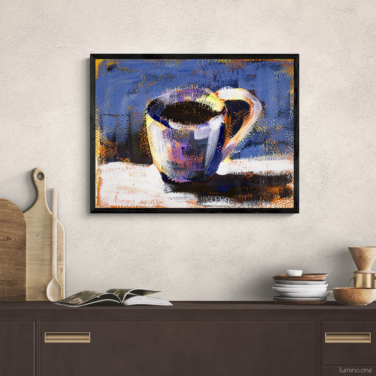 Coffee cup art print in black frame displayed on textured white wall above dark wood kitchen cabinet. Impressionist style coffee mug painting with vibrant blue background, styled with wooden cutting boards, kitchen utensils, stacked plates and wooden bowls. Modern kitchen wall decor for coffee lovers, perfect for coffee bar, breakfast nook, or dining area with natural wood accents.