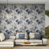 Classic blue peony toile wallpaper shown as accent wall in stylish living room with gray sectional sofa and contemporary furnishings