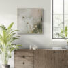 Botanical canvas print featuring sage green wildflowers in silver float frame, displayed above natural wood sideboard in bright Scandinavian dining room with large arched window, bird of paradise plant, and neutral tile flooring