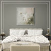 Botanical canvas print featuring sage green wildflowers in white float frame, displayed above neutral upholstered bed with tufted headboard in modern master bedroom with gray accent wall, white bedding, and decorative wall molding