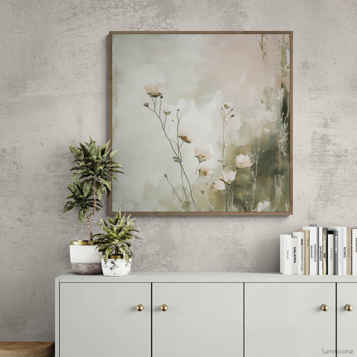 Botanical canvas print featuring sage green wildflowers in natural wood float frame, displayed above gray modern console cabinet with brass hardware against concrete textured wall, styled with potted plants and books