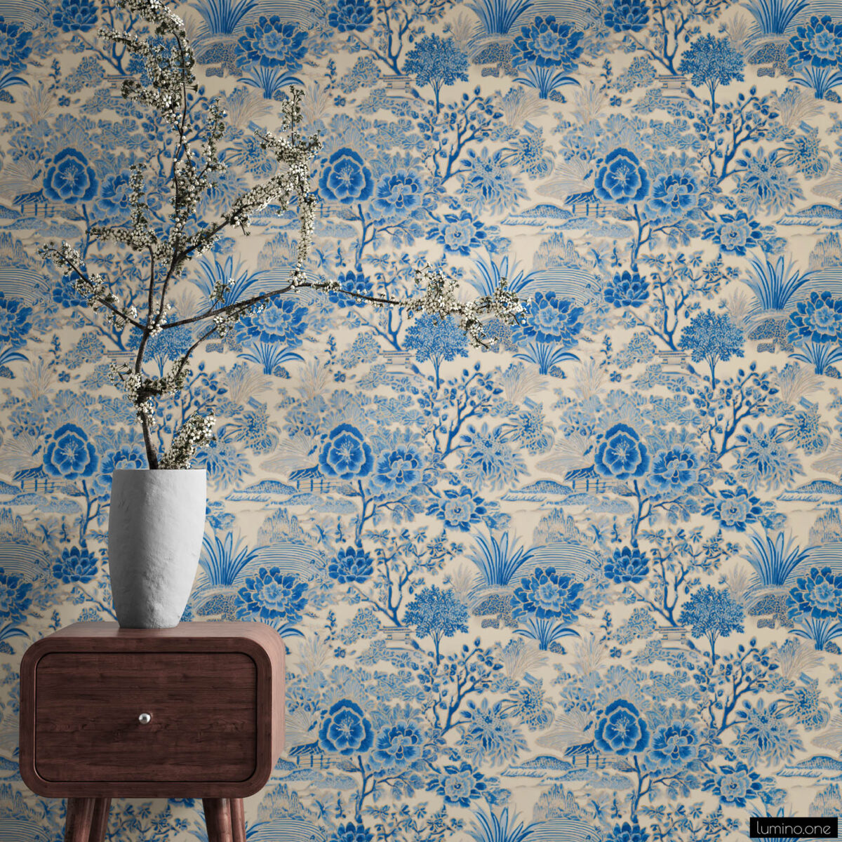 Blue Toile Peel and Stick Wallpaper - Vintage Botanical Garden P Blue and white toile peel and stick wallpaper on a full wall behind a mid-century modern walnut nightstand, featuring a vintage botanical garden pattern with large peony flowers and trees. Styled with a tall white textured vase holding dramatic white cherry blossom branches, showcasing the wallpaper's scale and detail in a bedroom setting.