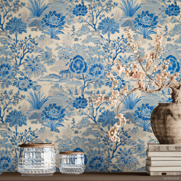Blue Toile Peel and Stick Wallpaper - Vintage Botanical Garden P Blue and white toile peel and stick wallpaper on a full wall behind a taupe modern sideboard, featuring a vintage botanical garden pattern with large peony flowers and trees. Styled with a rustic stoneware vase holding cherry blossom branches, stacked vintage books, and crystal glass jars with brass lids.