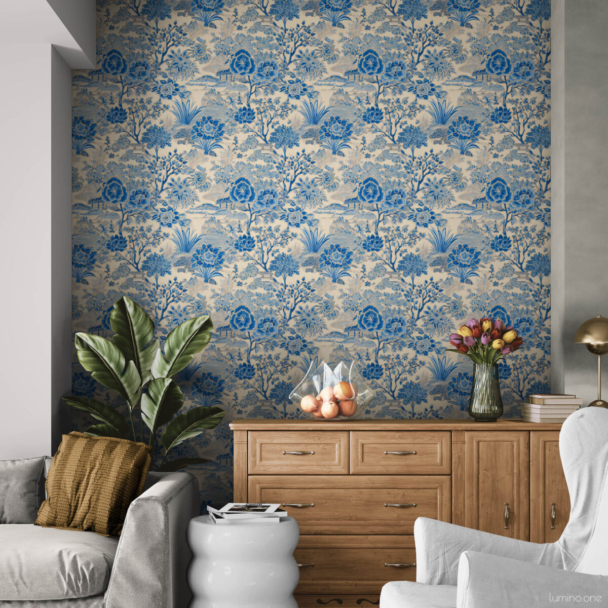 Blue and White Toile Wallpaper Peel and Stick - Vintage Botanica Blue and white toile peel and stick wallpaper on a recessed accent wall in a cozy living room, featuring a vintage botanical garden pattern with flowers and trees. Styled with a light wood dresser, tulips in a glass vase, slipcovered armchairs, a tropical houseplant, and a modern bubble side table on a white shag rug.