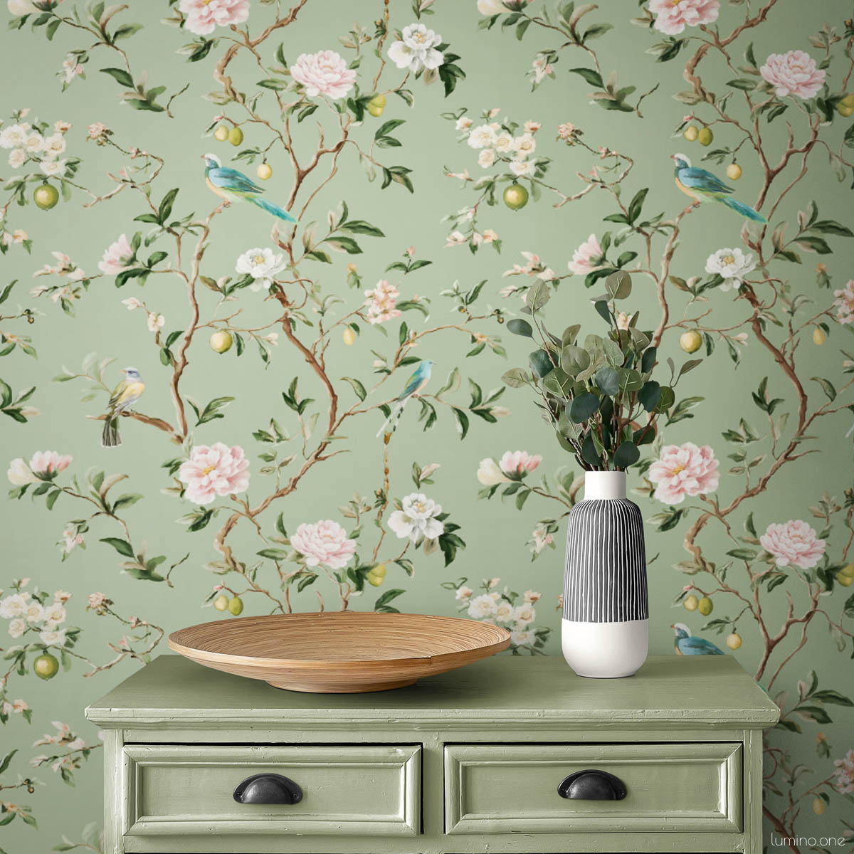 Chinoiserie Bird Wallpaper Peel and Stick - Sage Green Botanical Sage green chinoiserie vintage wallpaper with hand-painted birds, pink peonies, and lemon branches styled with matching sage green dresser with black cup pulls, wooden bowl, and striped ceramic vase with eucalyptus