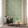Chinoiserie Bird Wallpaper Peel and Stick - Sage Green Botanical Sage green chinoiserie botanical wallpaper feature wall with hand-painted birds, pink peonies, and lemon branches in bright room with green velvet chair, gold pillow, beige curtains, and natural wood coffee table