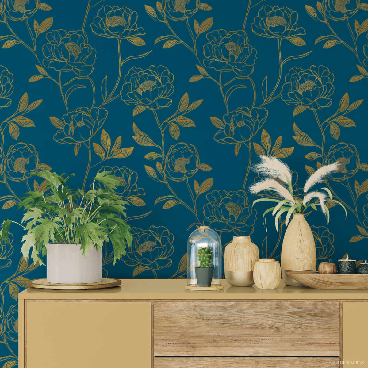 Boho living room vignette with dark teal and gold peony removable wallpaper behind a mustard yellow mid-century sideboard styled with wood vases, pampas grass, a green fern, and a glass cloche