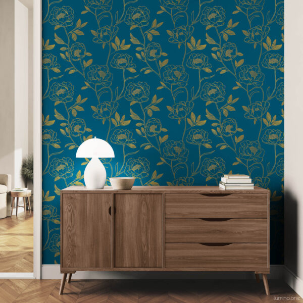 Modern hallway accent wall with dark teal and gold botanical peony peel and stick wallpaper, styled with a mid-century walnut dresser, white mushroom table lamp, and stacked books on a herringbone wood floor