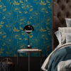 Moody bedroom accent wall with dark teal and gold botanical peony removable wallpaper, styled with a tufted leather headboard, teal bedding, and black dome table lamp on wood floors